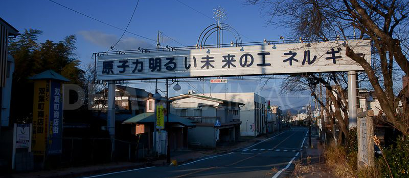 There is a sign with slogan at the empty street of Futaba, within the 20km Fukushima nuclear exclusion zone, Japan. It says: Nuclear energy for a bright future.